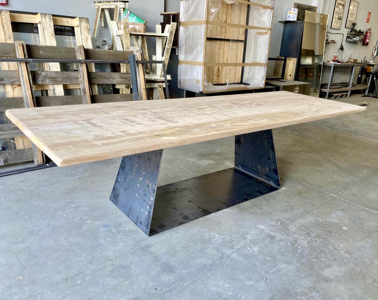 Mesa de diseño con sobre de madera y pie de acero tipo góndola